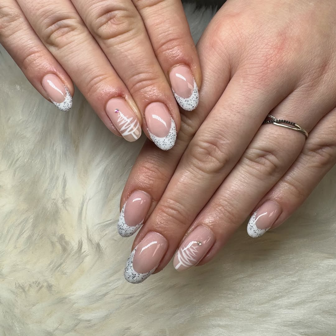 Manucure french blanche pailletée avec motifs de Noël sur fond de fausse fourrure blanche